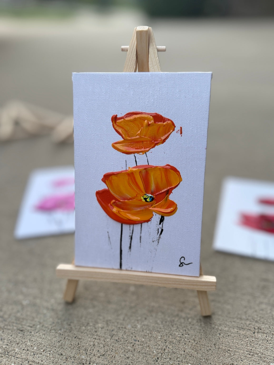 Orange Sam Glenn poppy painting on a 4x6 canvas board with a wooden easel