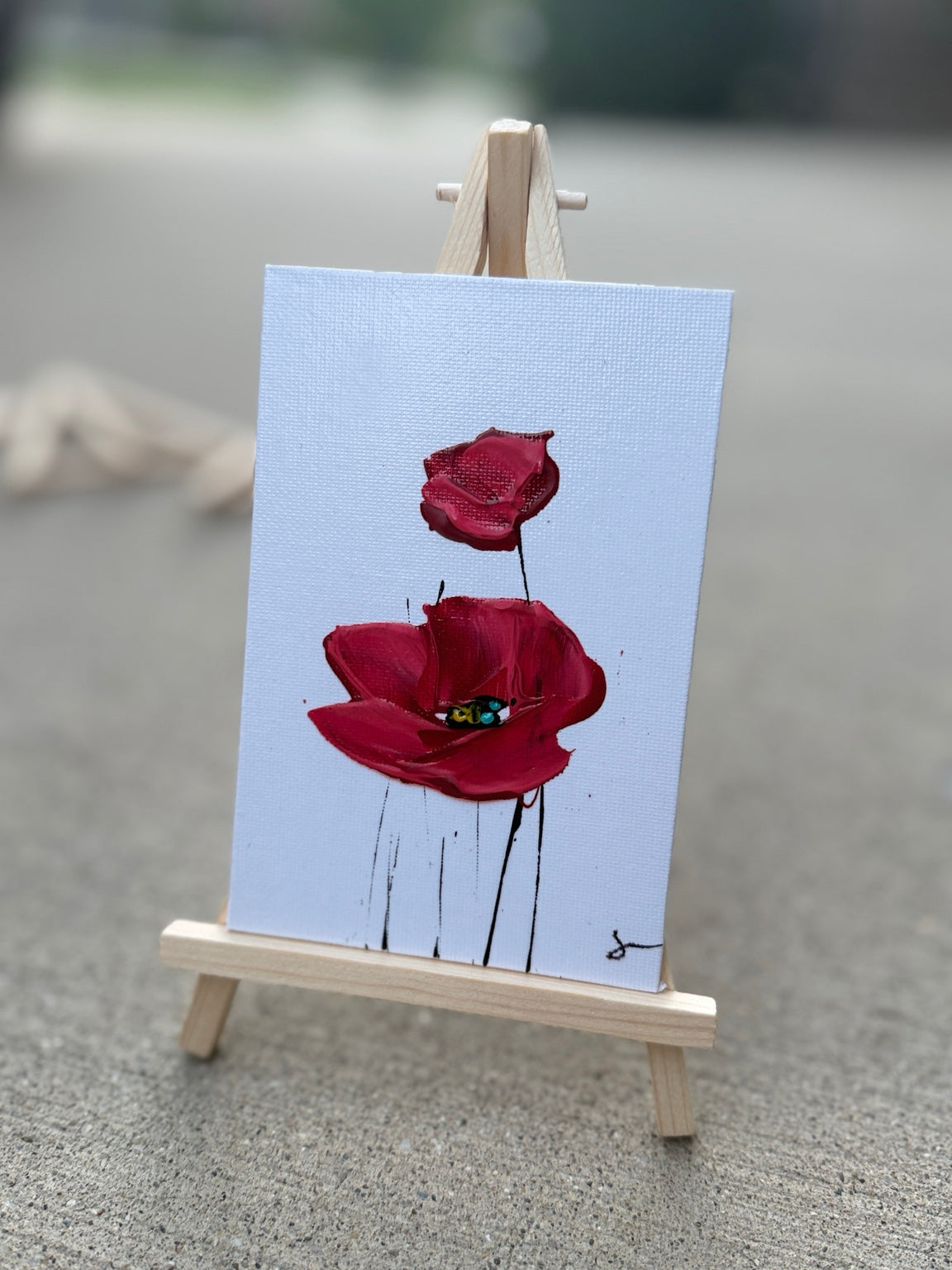Red Sam Glenn poppy painting on a 4x6 canvas board with a wooden easel